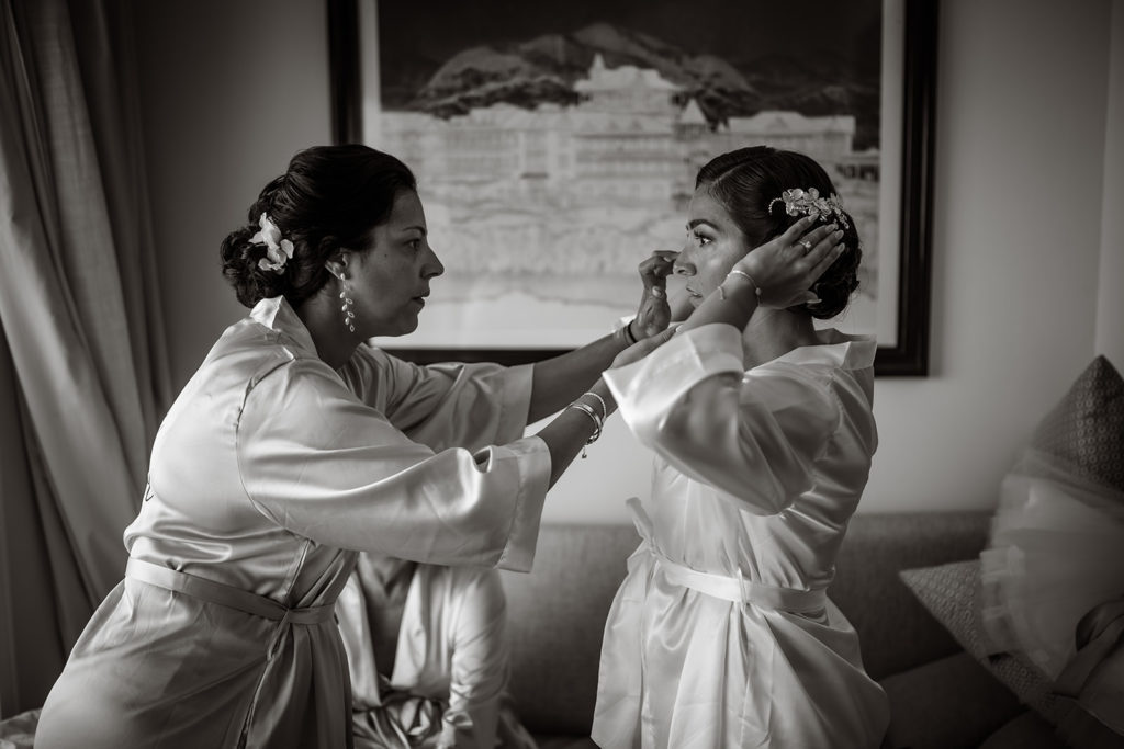 A bride and her sister adjust her hair before her Caribbean Destination Wedding photographed by TKM Photography located in Roatan, Honduras and Durham Region, Ontario