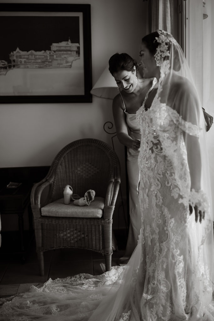 A bride and her sister stand in front a window before a Caribbean Destination Wedding photographed by TKM Photography located in Roatan, Honduras and Durham Region, Ontario